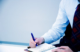 Businessman writing in planner